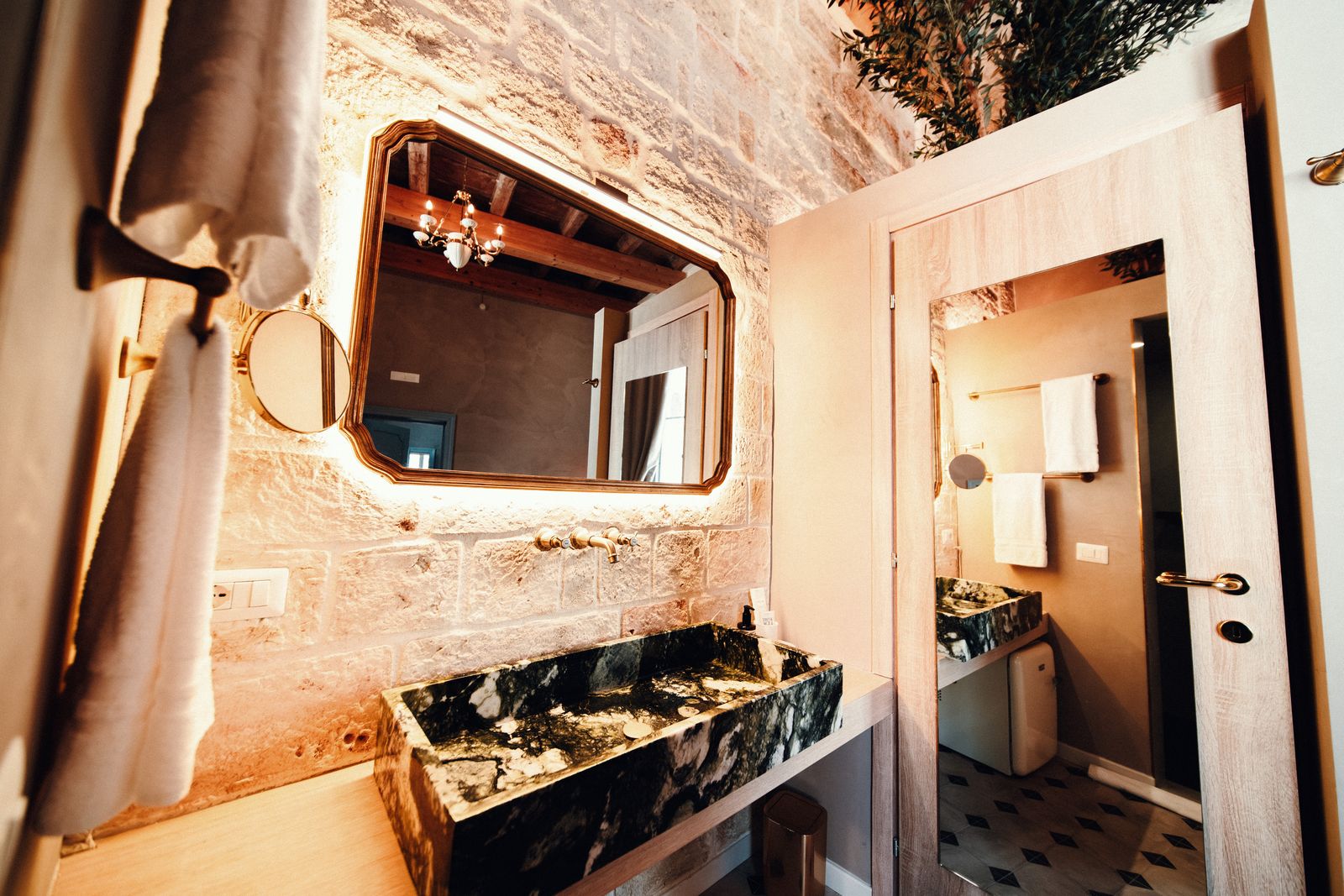 The green marble sink under the lit mirror.