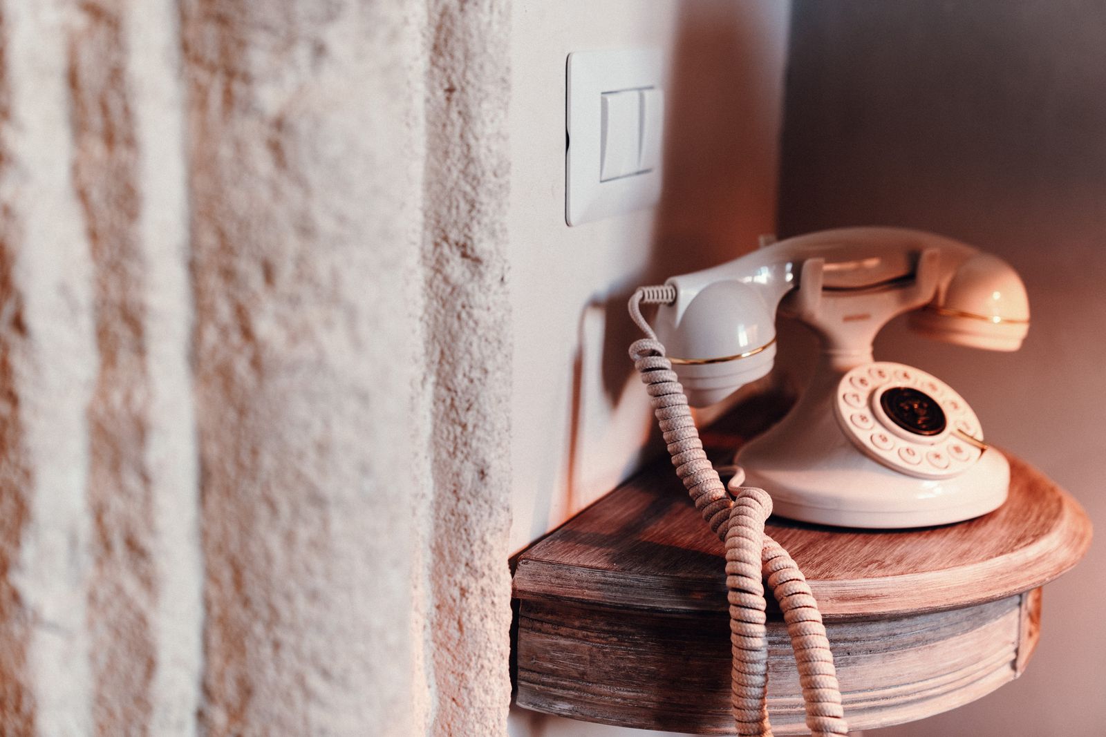 A vintage telephone on a wooden shelf.