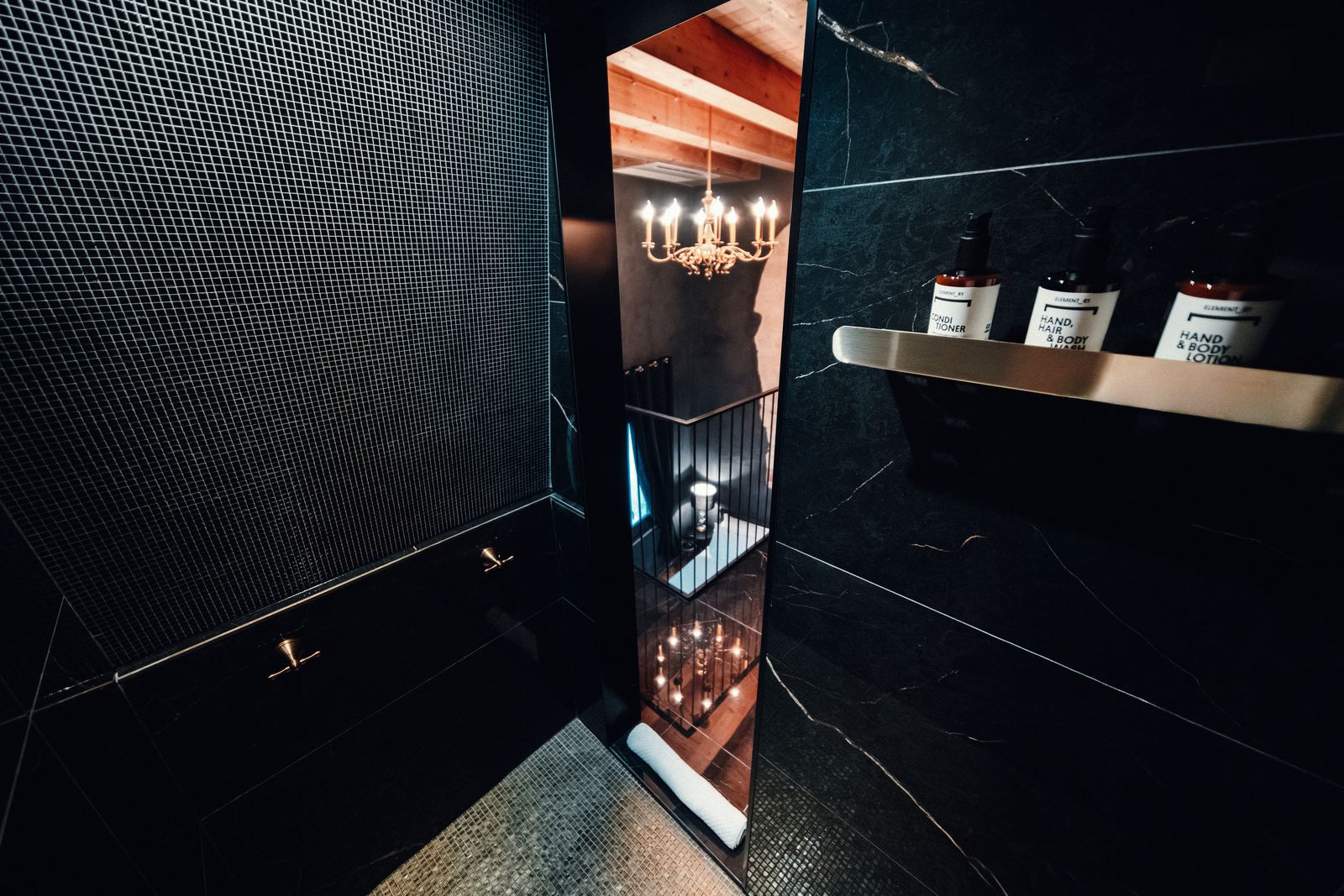 Dark marble, and the chandelier through the doorway.