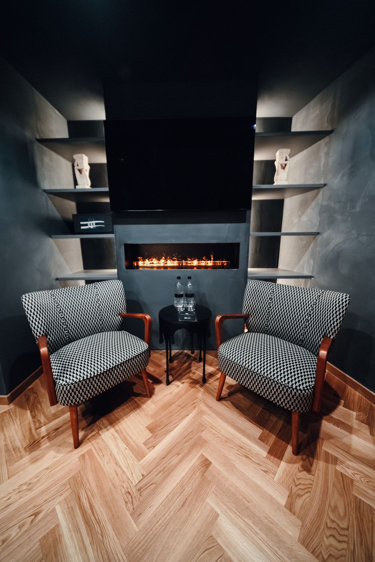 The fireplace and two checkered armchairs.