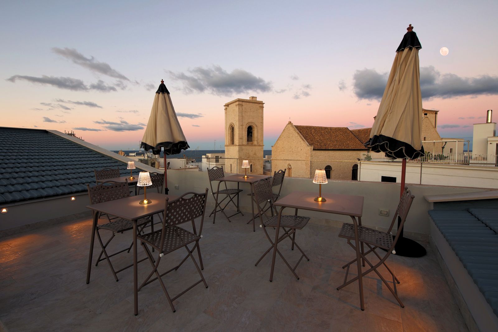 Dusk on the terrace, lanterns lit on the tables.